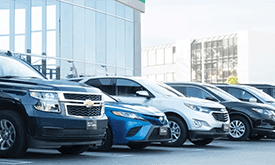 A row of cars parked in front of a building.